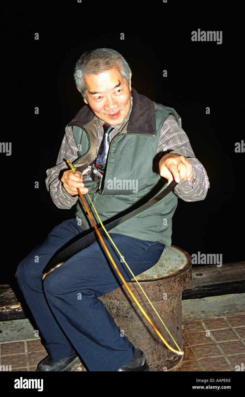 Hombre tocando el serrucho, Kowloon, Hong Kong, China Foto de stock