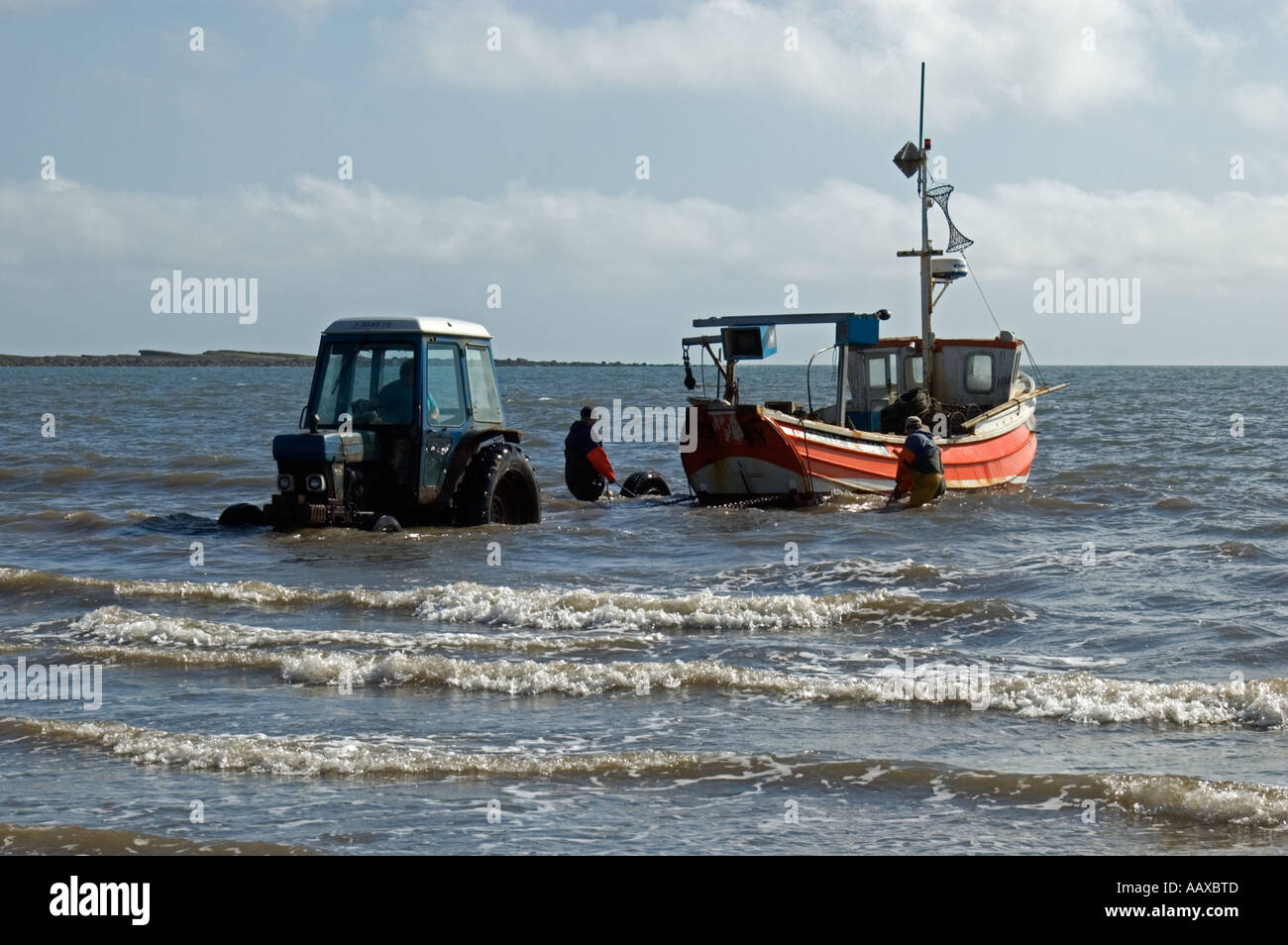 Coble pescadores trayendo en su captura después de un viaje de pesca mar adentro en el aterrizaje coble Filey North Yorkshire, Inglaterra Foto de stock