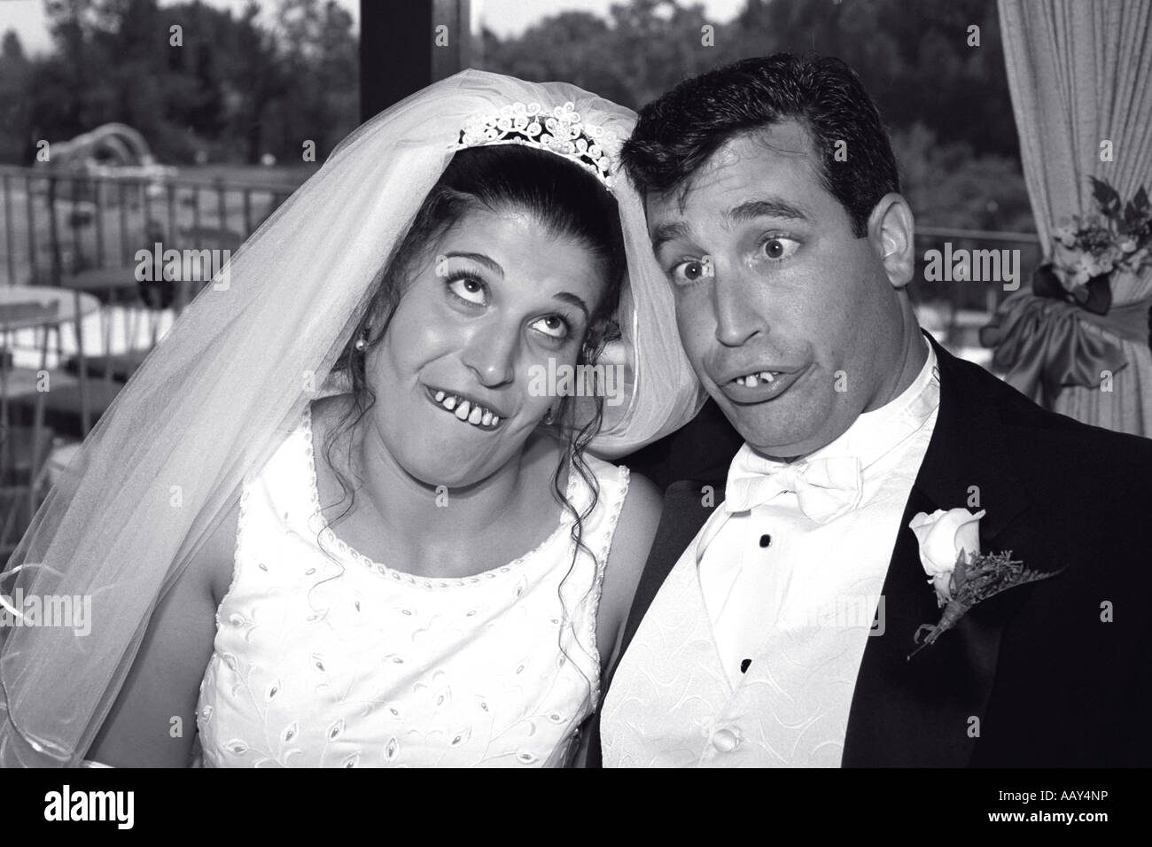 Goofy pareja en boda haciendo muecas para el novio y la novia tonta feliz blanco y negro horizontal Foto de stock
