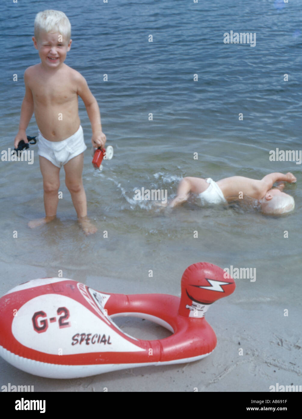 Conflicto entre los hermanos del bebé en la orilla del lago Foto de stock