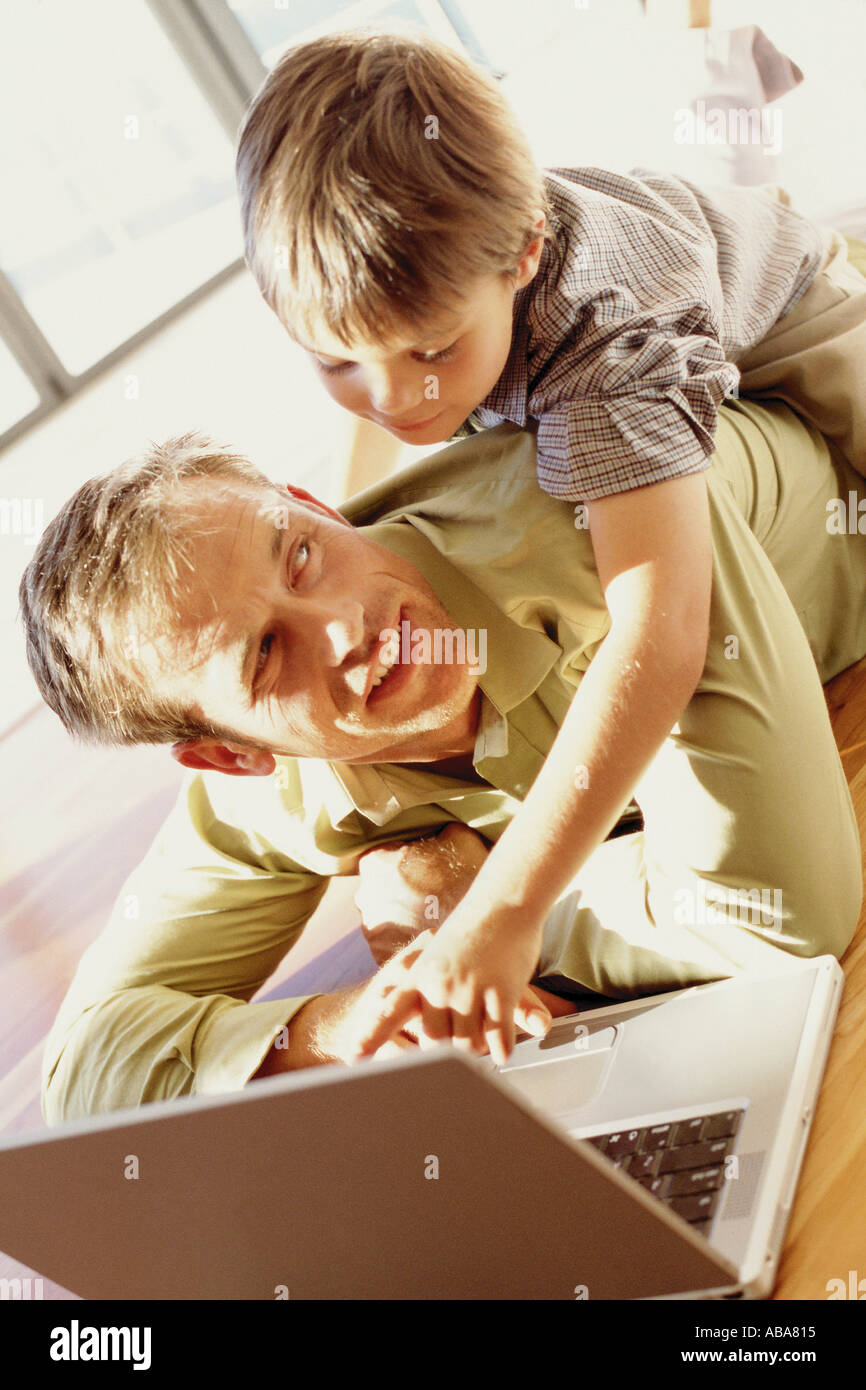 Padre e hijo jugando con un portátil Foto de stock