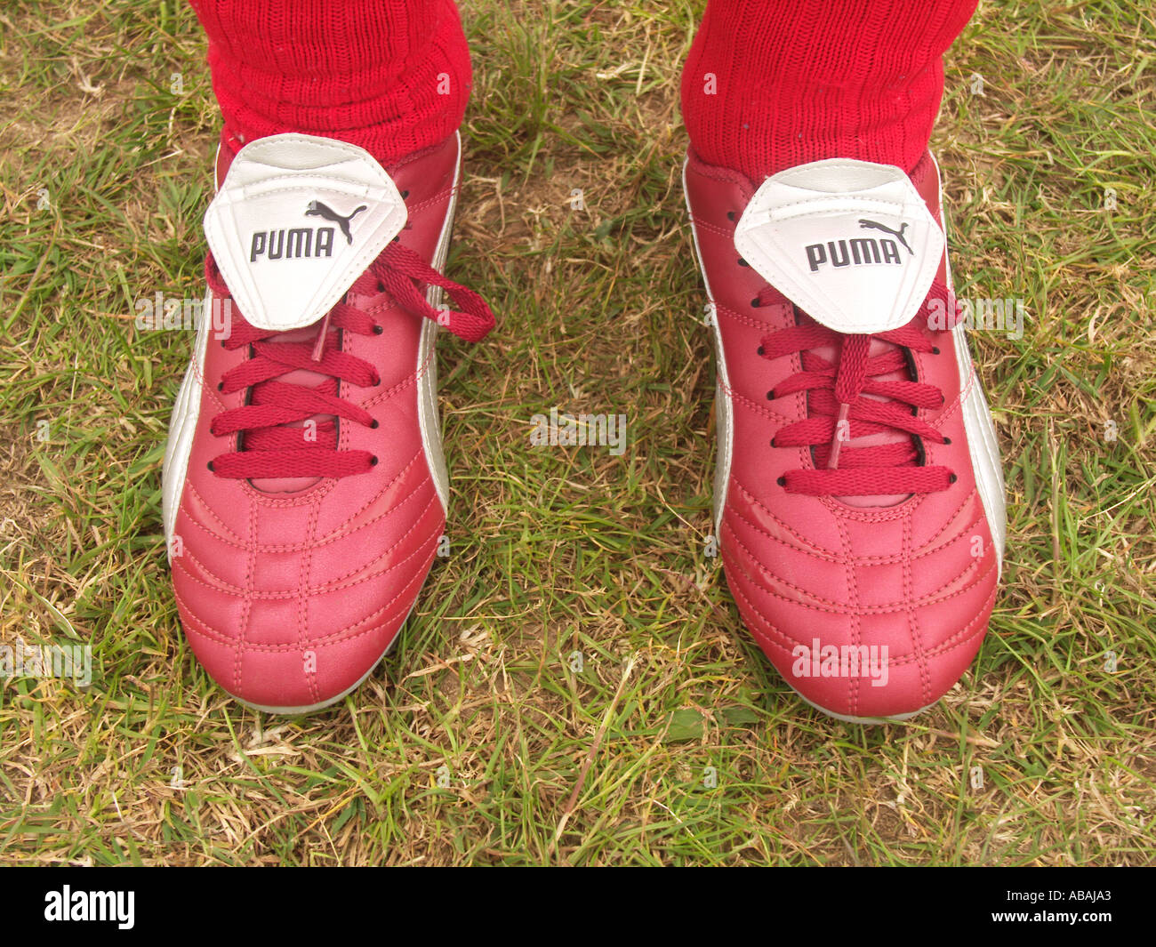 Las nuevas botas de fútbol Puma rojo y calcetines rojos desgastados por  niño Fotografía de stock - Alamy