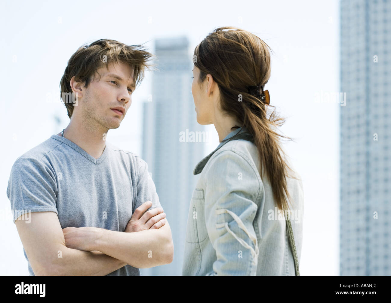 Pareja joven habiendo argumento delante de highrises Foto de stock