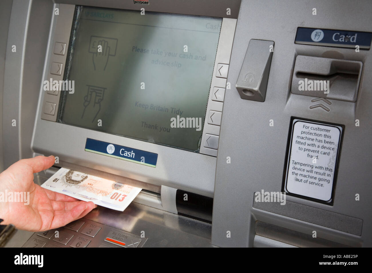 Cajero automático agujero en el muro cajero automático retirar pantalla de dinero con la mano de un pensionista tomando pagarés de 10 libras esterlinas. Inglaterra Reino Unido Gran Bretaña Foto de stock