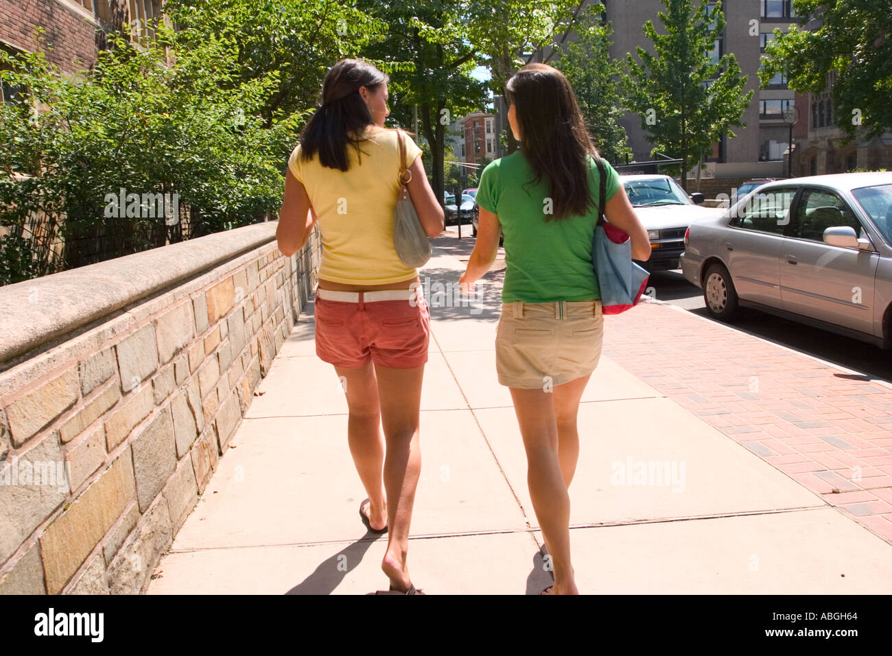 Las niñas adolescentes asiendo firmemente sus monederos caminando por una  calle de la ciudad Fotografía de stock - Alamy
