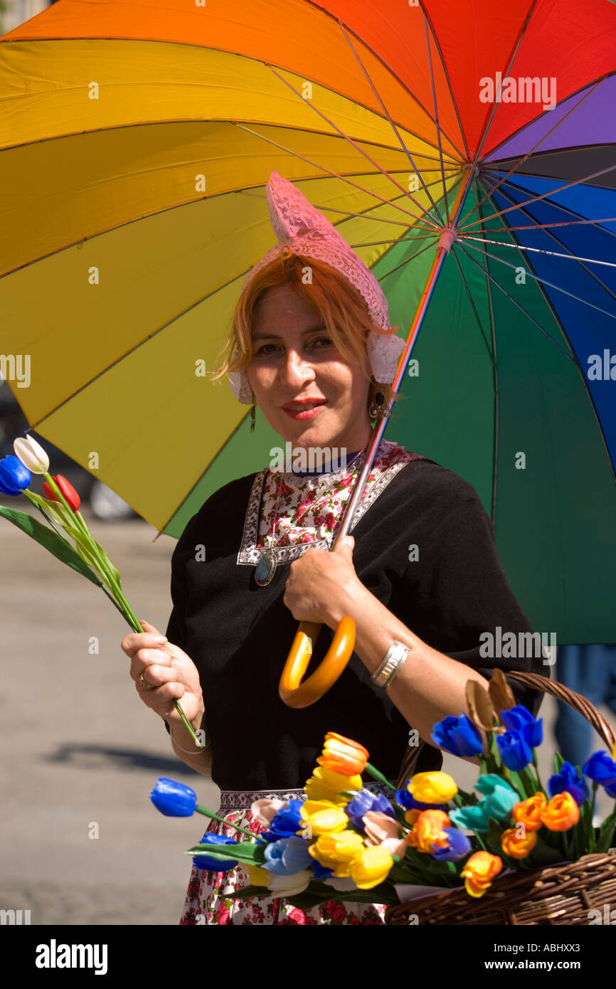 Vestido tradicional de la mujer en la venta de tulipanes en la Presa de Amsterdam Holanda Holanda Foto de stock