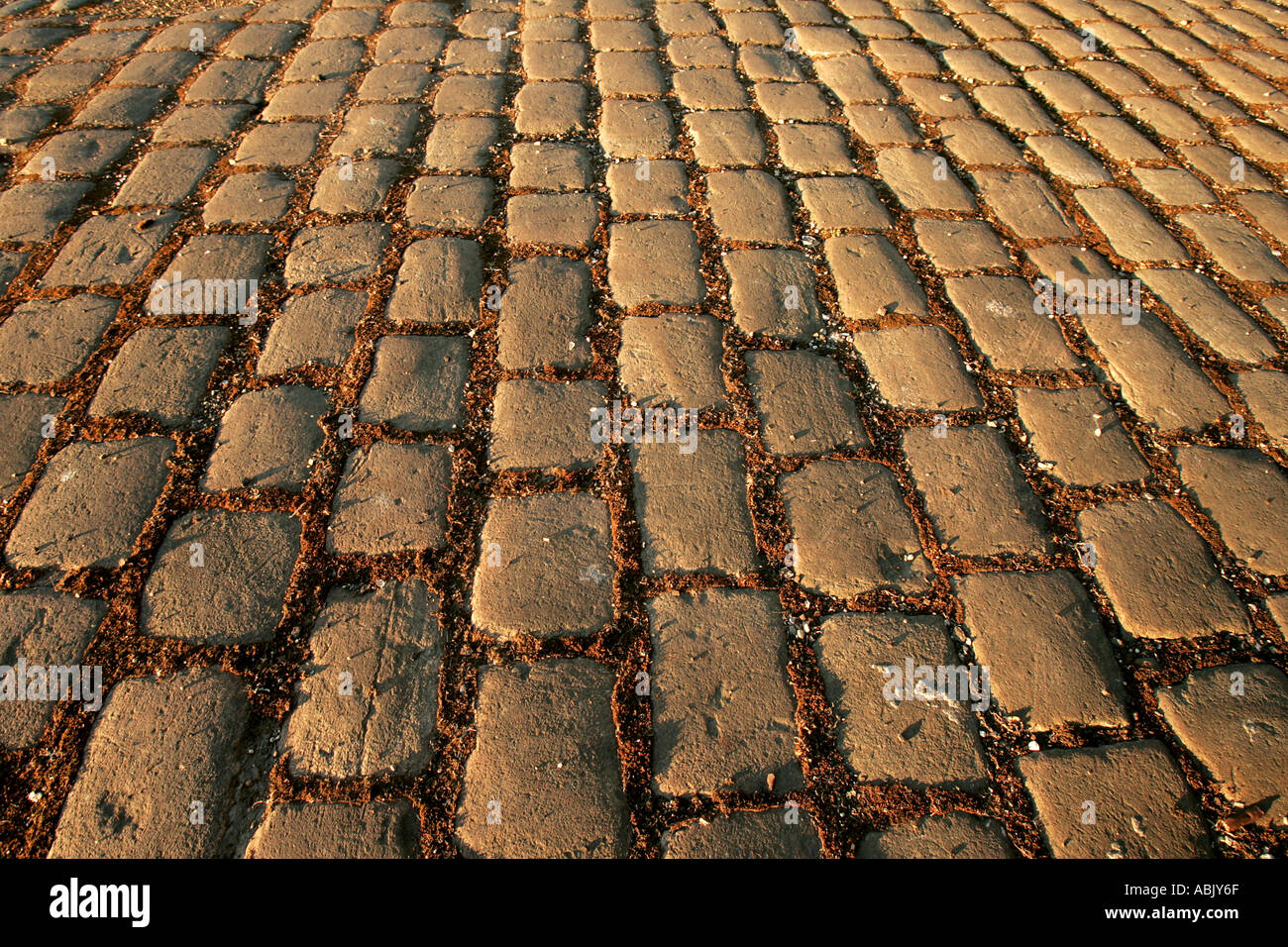 Adoquines de piedra de colores cálidos sunset road calle camino de carro viejo diseño restauración de patrimonio histórico la perspectiva diagonal infini Foto de stock