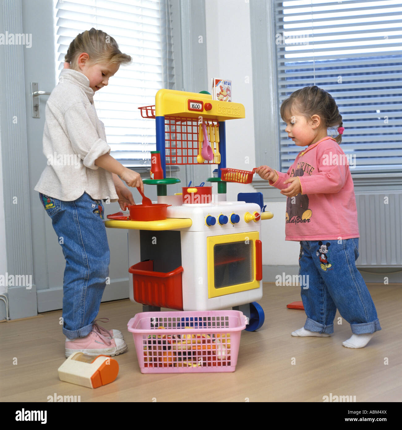 Niñas jugando con una cocina de juguete Fotografía de stock - Alamy