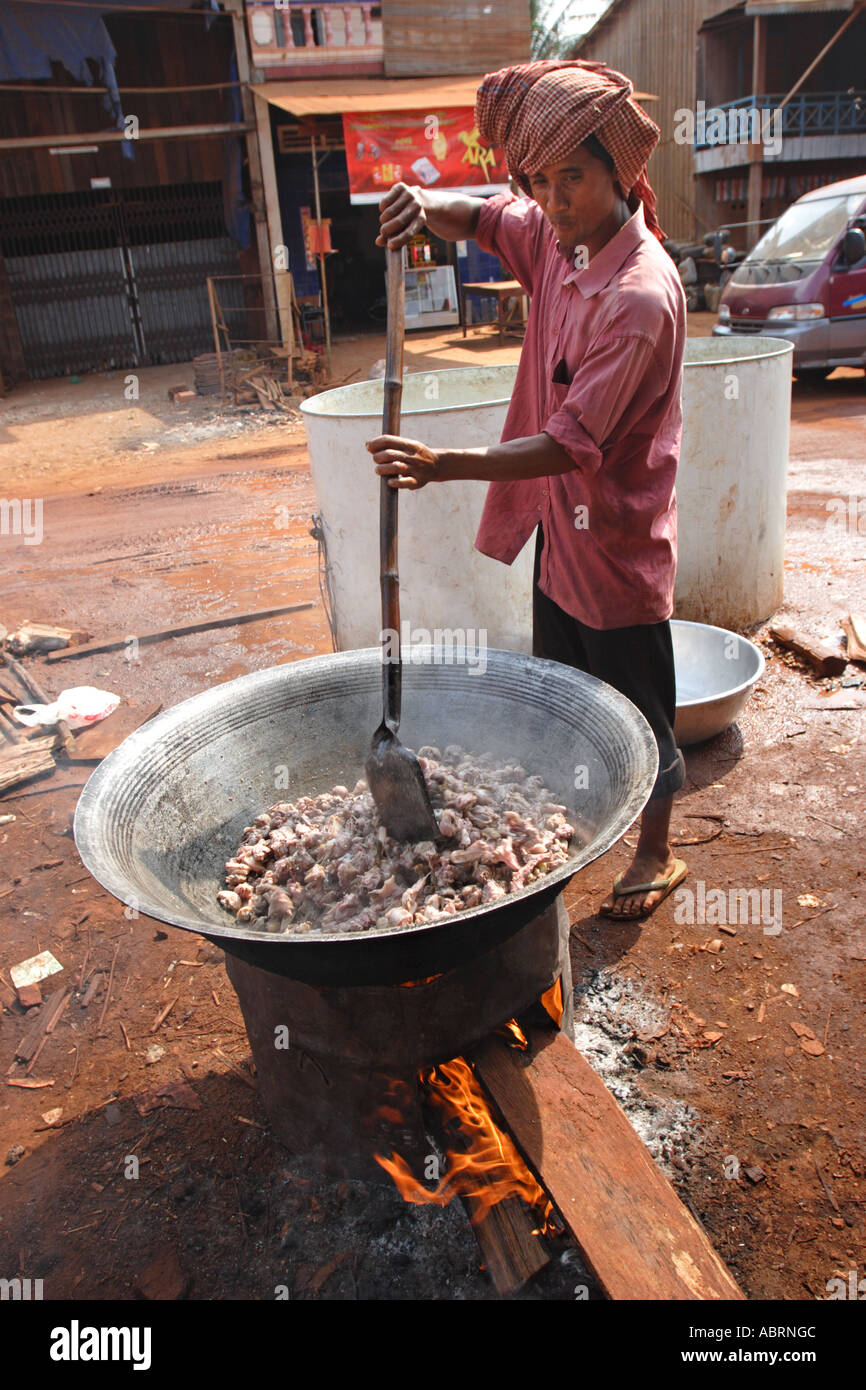 Un hombre prepara una olla gigante de los pedazos de pollo en un mercado en  el norte de Camboya Fotografía de stock - Alamy