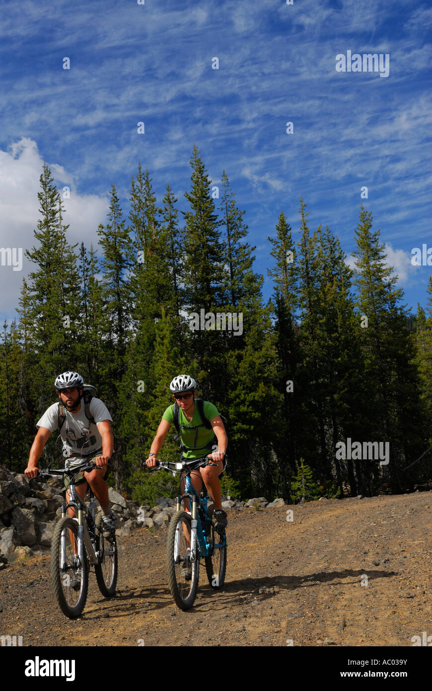 Un par de ciclistas de montaña con cascos en la carretera de terracería con blue sky Oregón EE.UU. Foto de stock