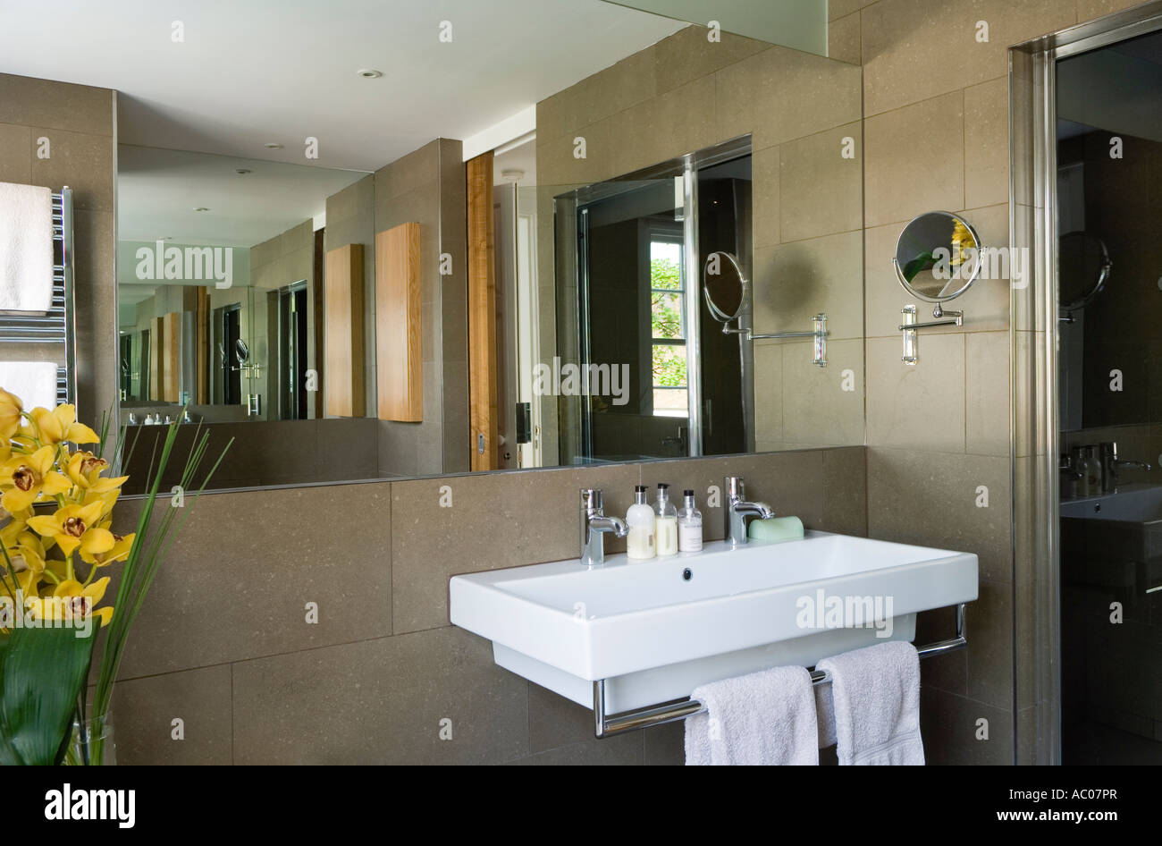 Lavabo de baño modernista con un gran espejo y azulejos de cerámica Foto de stock