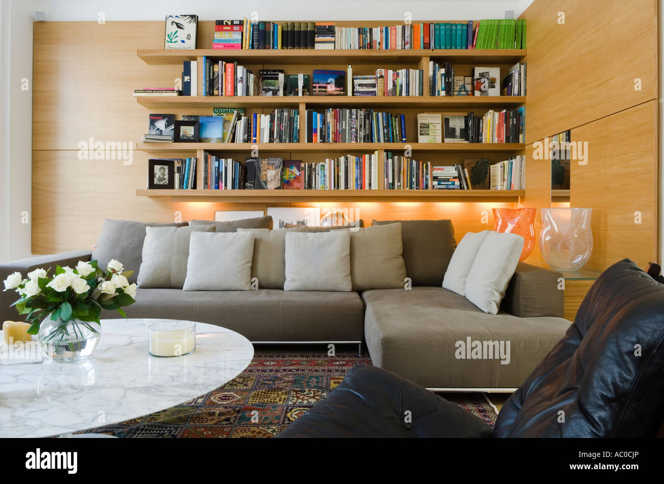 La moderna sala de estar con biblioteca, 2 piezas de sofá y mesa de café Foto de stock