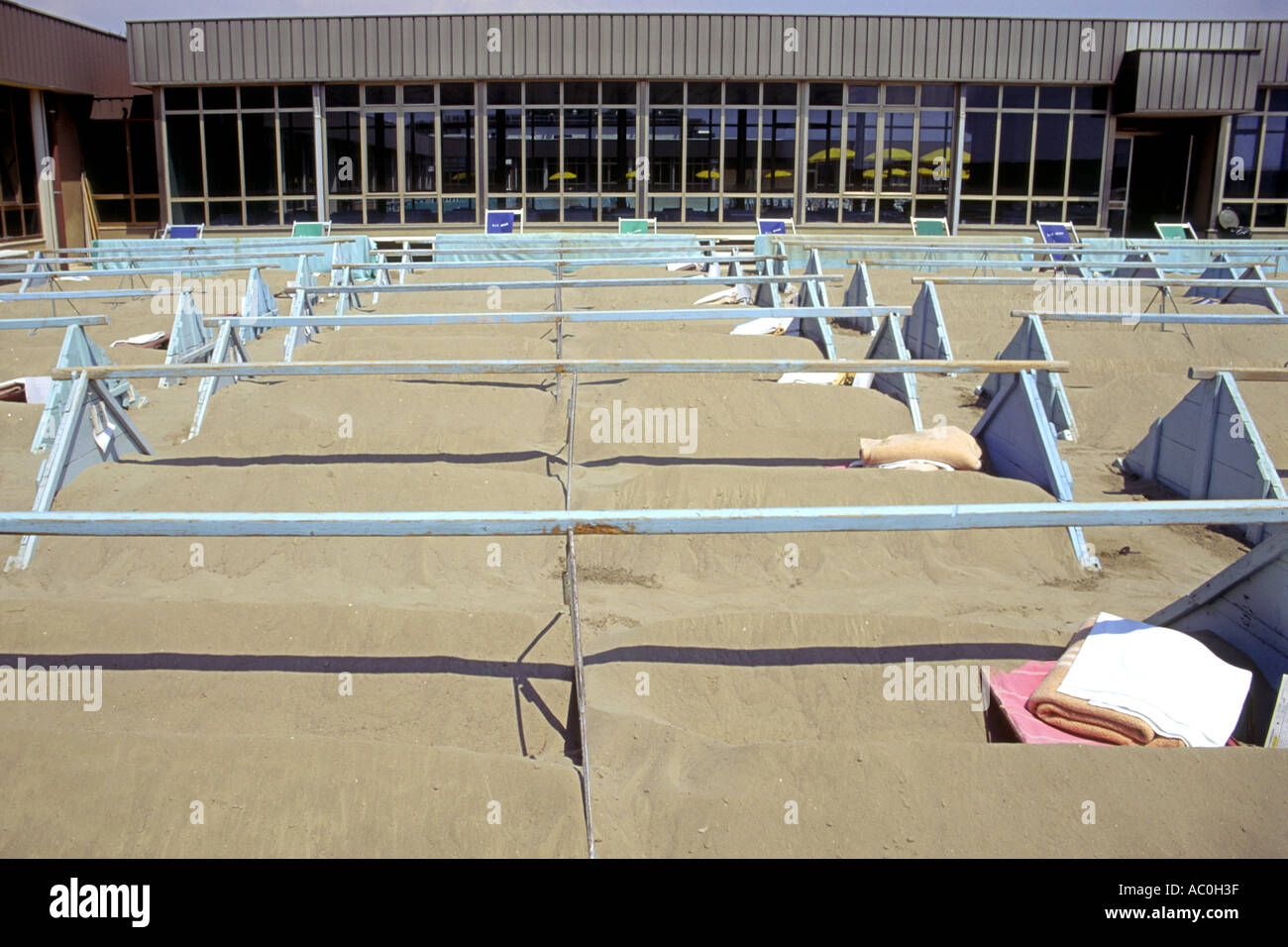 Lechos de arena en un spa de salud en grado, Italia. La gente se enterraron hasta el cuello en la arena caliente, y por lo tanto el sudor toxinas. Foto de stock