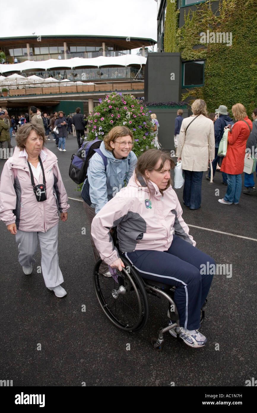 Discapacitados en silla de ruedas sportswoman empujados al Campeonato de tenis de Wimbledon UK Foto de stock