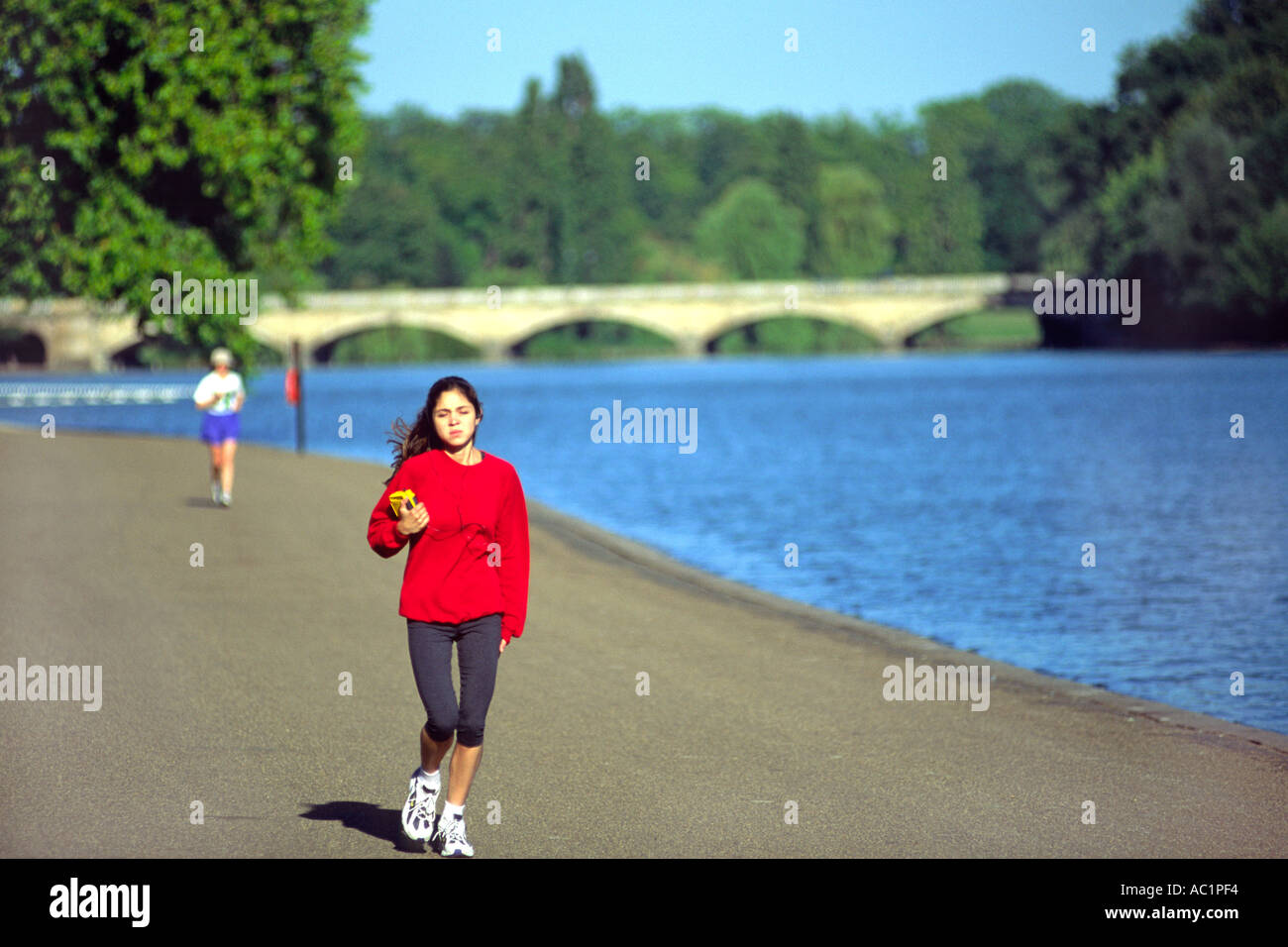 Una joven mujer avanza a lo largo de la Serpentine en Hyde Park en Londres. Foto de stock