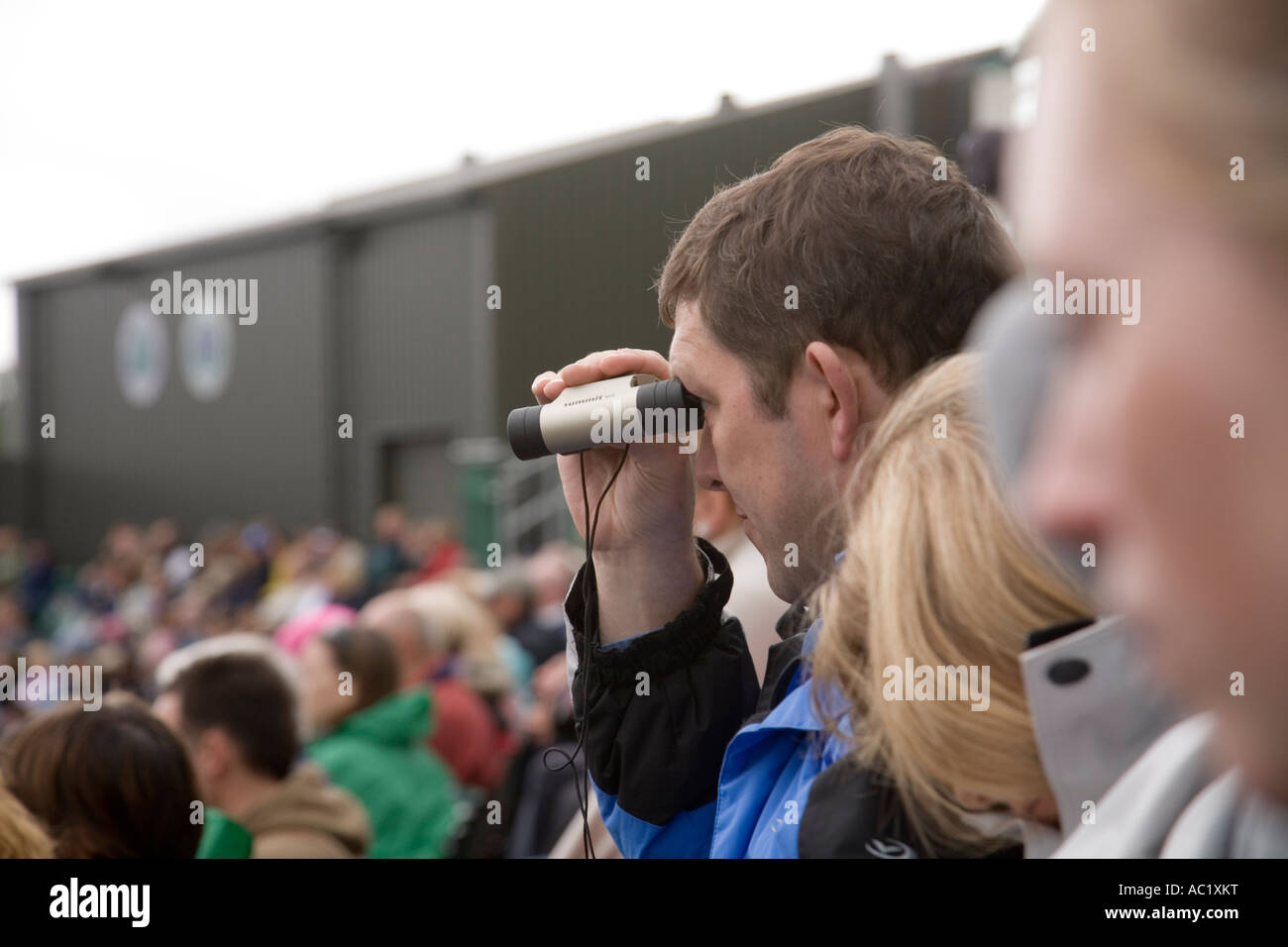 Relojes del ventilador a través de binoculares durante el juego en el centro de la cancha en el Campeonato de tenis de Wimbledon UK Foto de stock