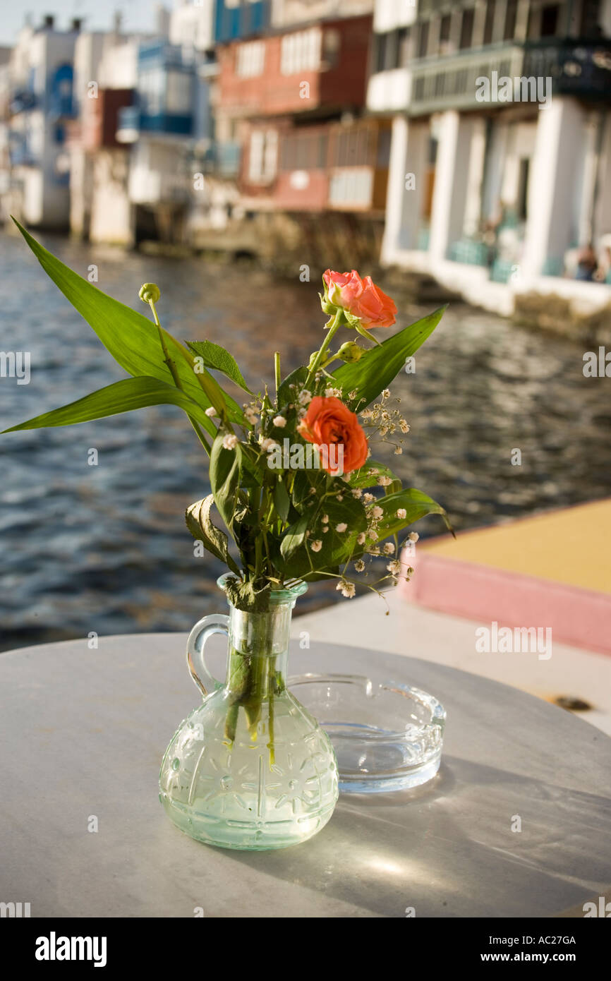 Jarrón con rosas de pie sobre una mesa de un restaurante La Pequeña Venecia de Mykonos Mykonos Grecia Foto de stock