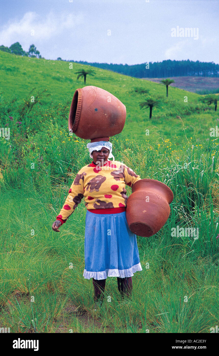 Mujer que llevaba la alfarería en cabeza en Mpumalanga Sudáfrica Foto de stock