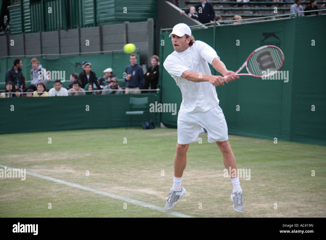 Jordan Kerr, con una devolución de revés, el Torneo de Tenis de Wimbledon, Londres, Inglaterra. Foto de stock