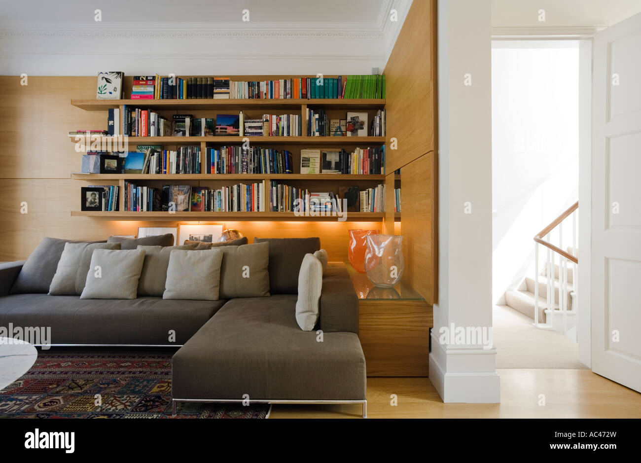 La moderna sala de estar con biblioteca y sofá gris de 2 piezas en la casa diseñado por Amodio Pasquale Foto de stock
