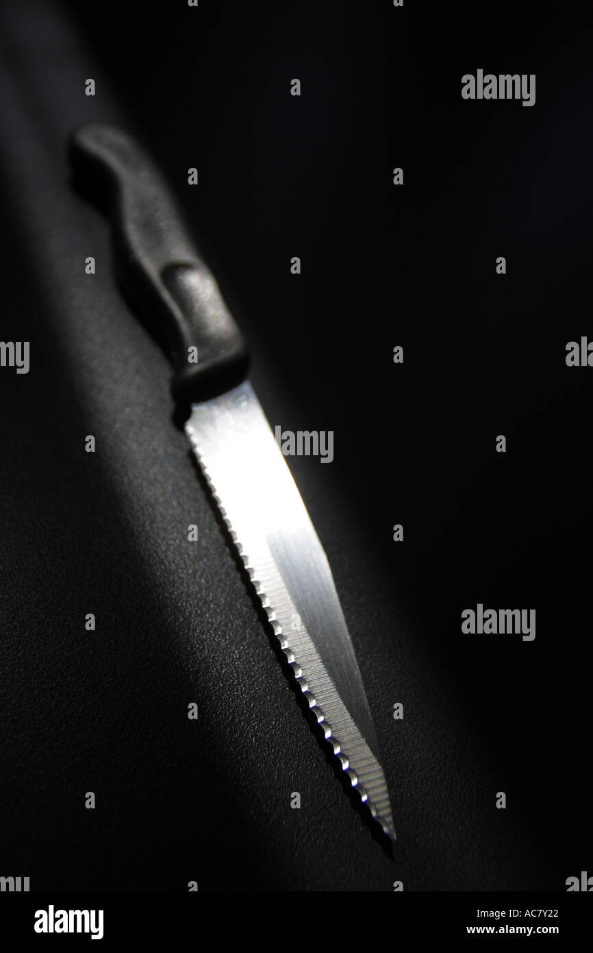 Cuchillo de cocina afilado sobre fondo negro con Spotlight Foto de stock
