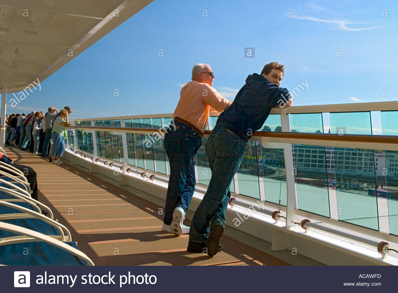 Los pasajeros a bordo del barco crucero mira sobre las barandillas de