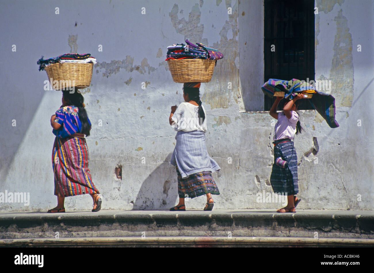 Las mujeres llevar productos al mercado en la mañana la ciudad de Antigua Guatemala Foto de stock