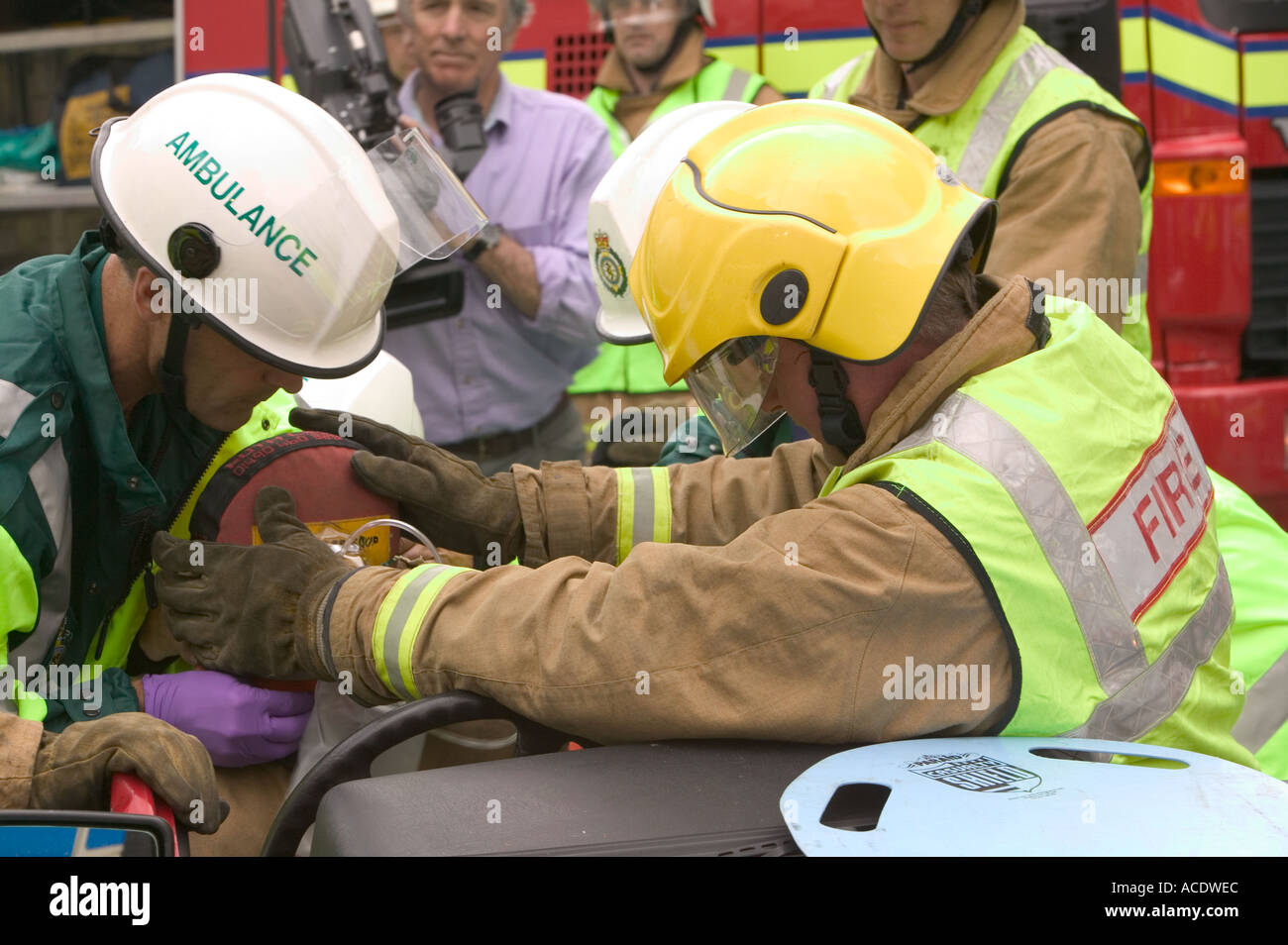 Paramédico de ambulancias y bomberos tratar un conductor lesionado en un accidente de automóvil escenario ejercicio de entrenamiento Foto de stock