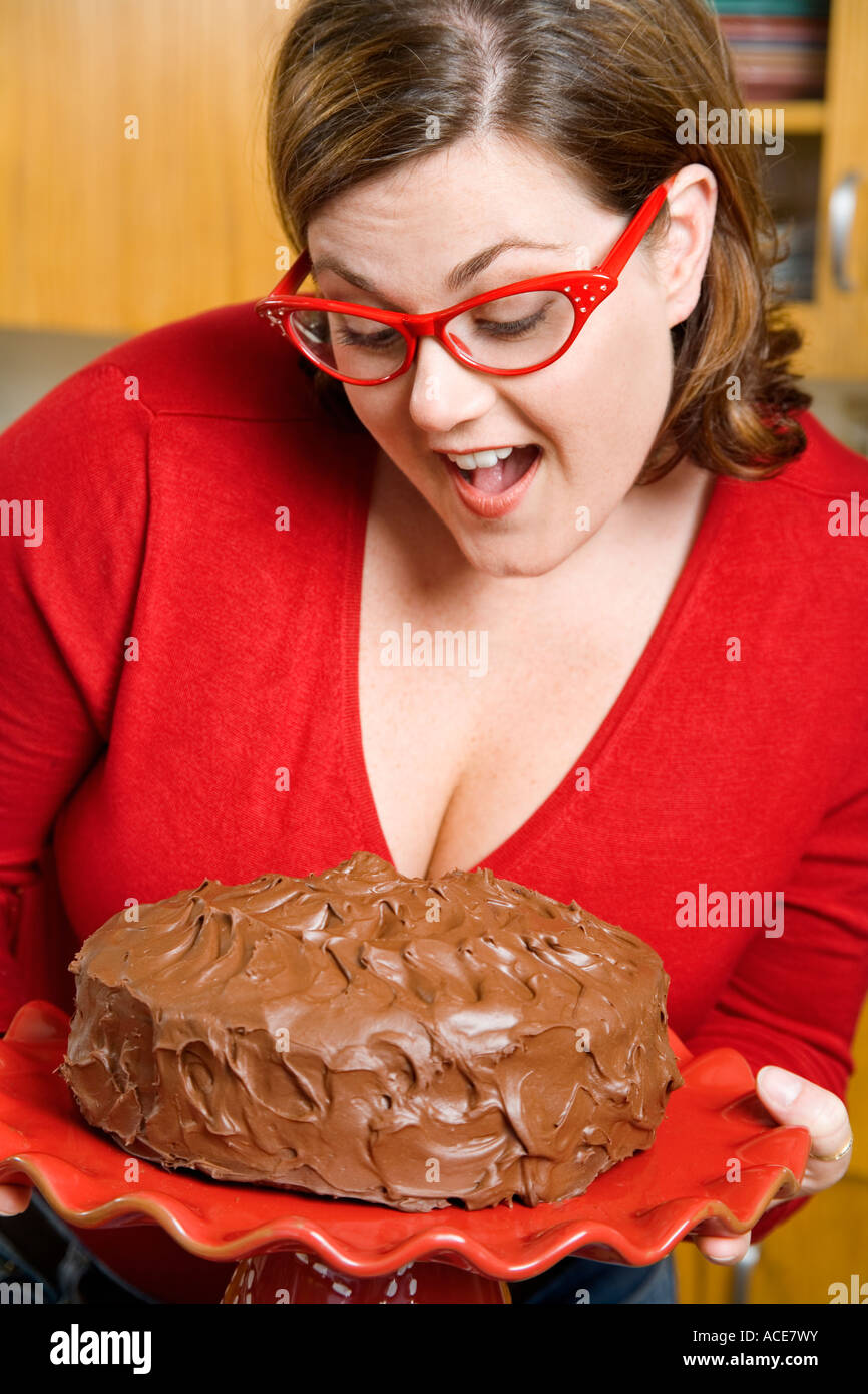Mujer inspeccionando frosted cake Foto de stock