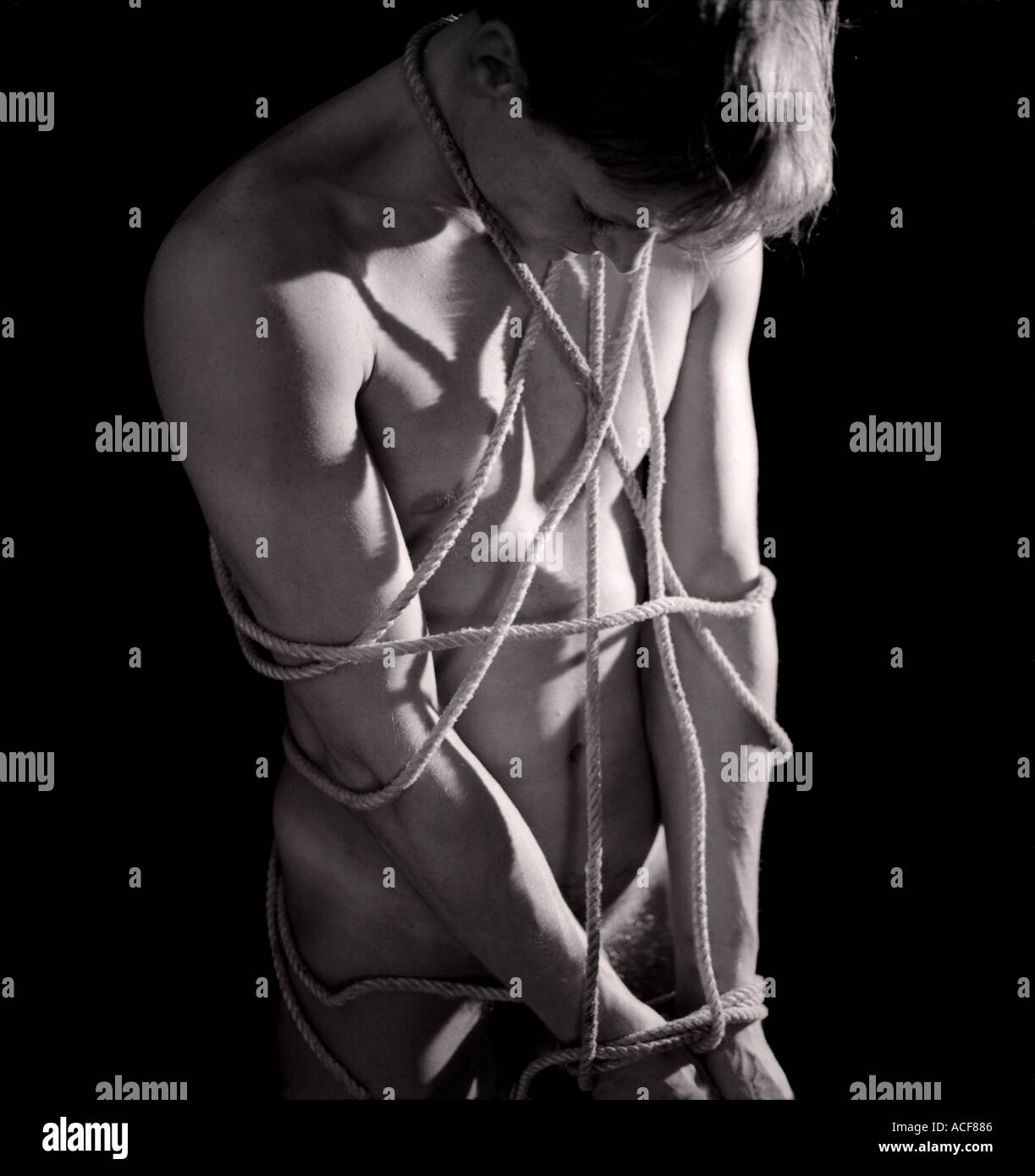 Hombre desnudo atado con cuerdas mirando hacia abajo Fotografía de stock -  Alamy