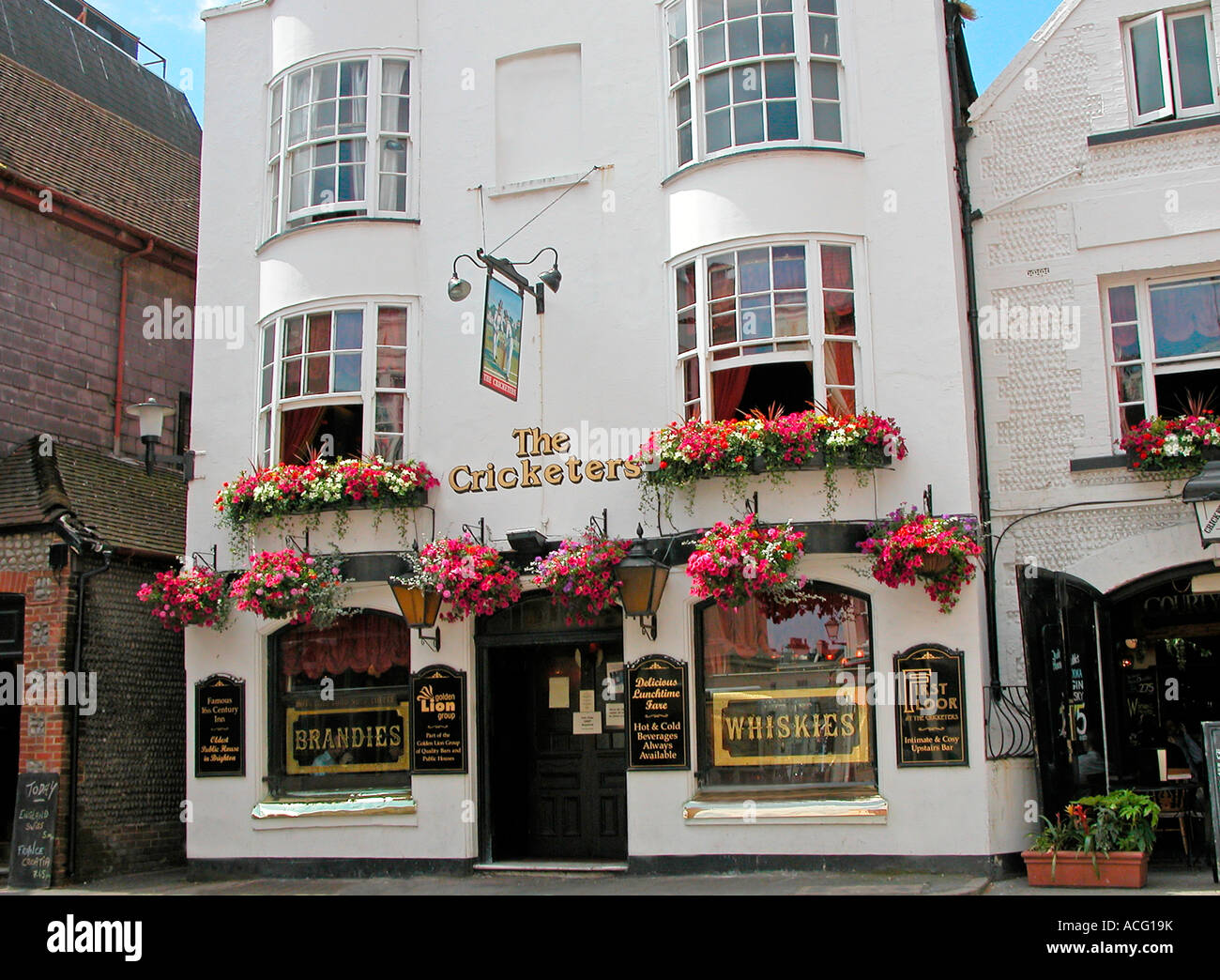 Coloridas flores en windowboxs y cestas colgantes fuera una casa pública en  East Sussex, Brighton Lanes Fotografía de stock - Alamy