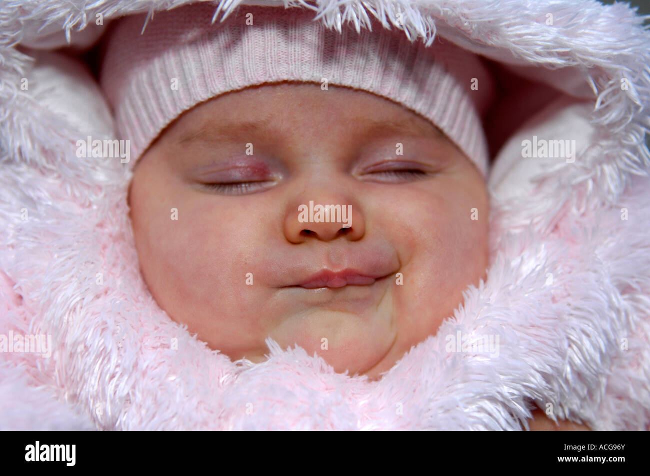 El sueño del bebé recién nacido retrato rostro caucásico femenino rosa protección para el ropa de abrigo Fotografía de stock - Alamy