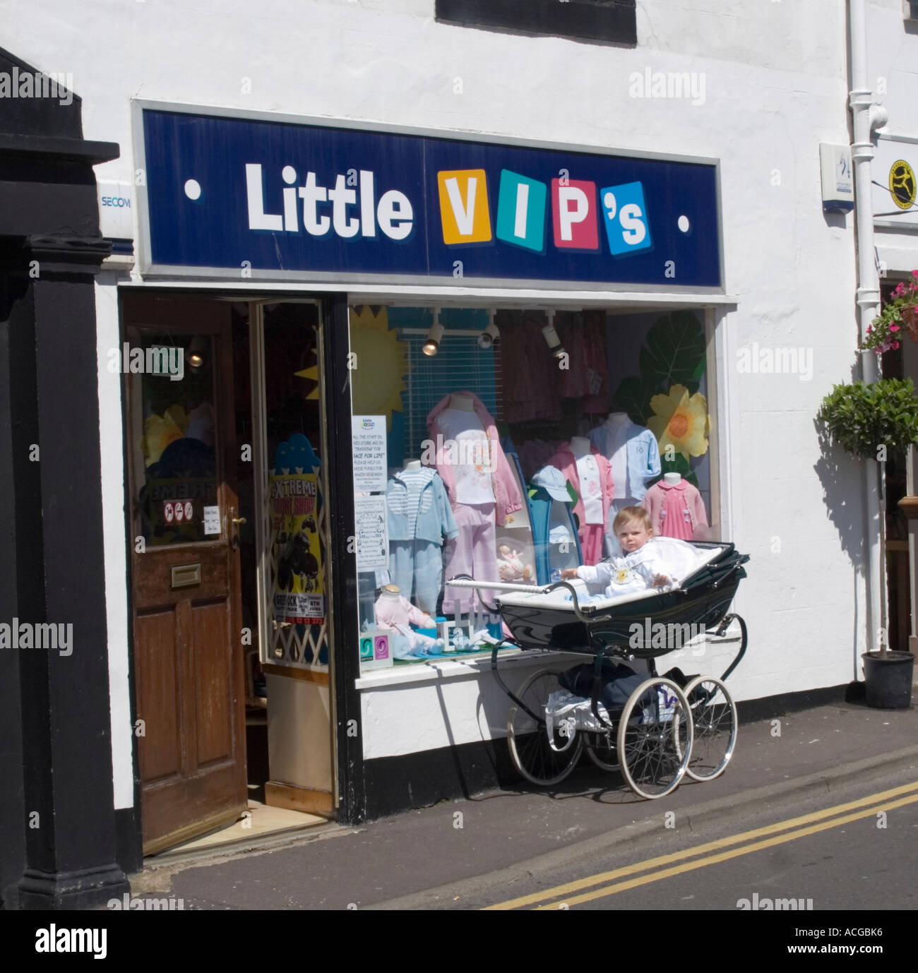 Niño en cruz de plata pram fuera VIP tienda de ropa para niños en Largs  Escocia Fotografía de stock - Alamy