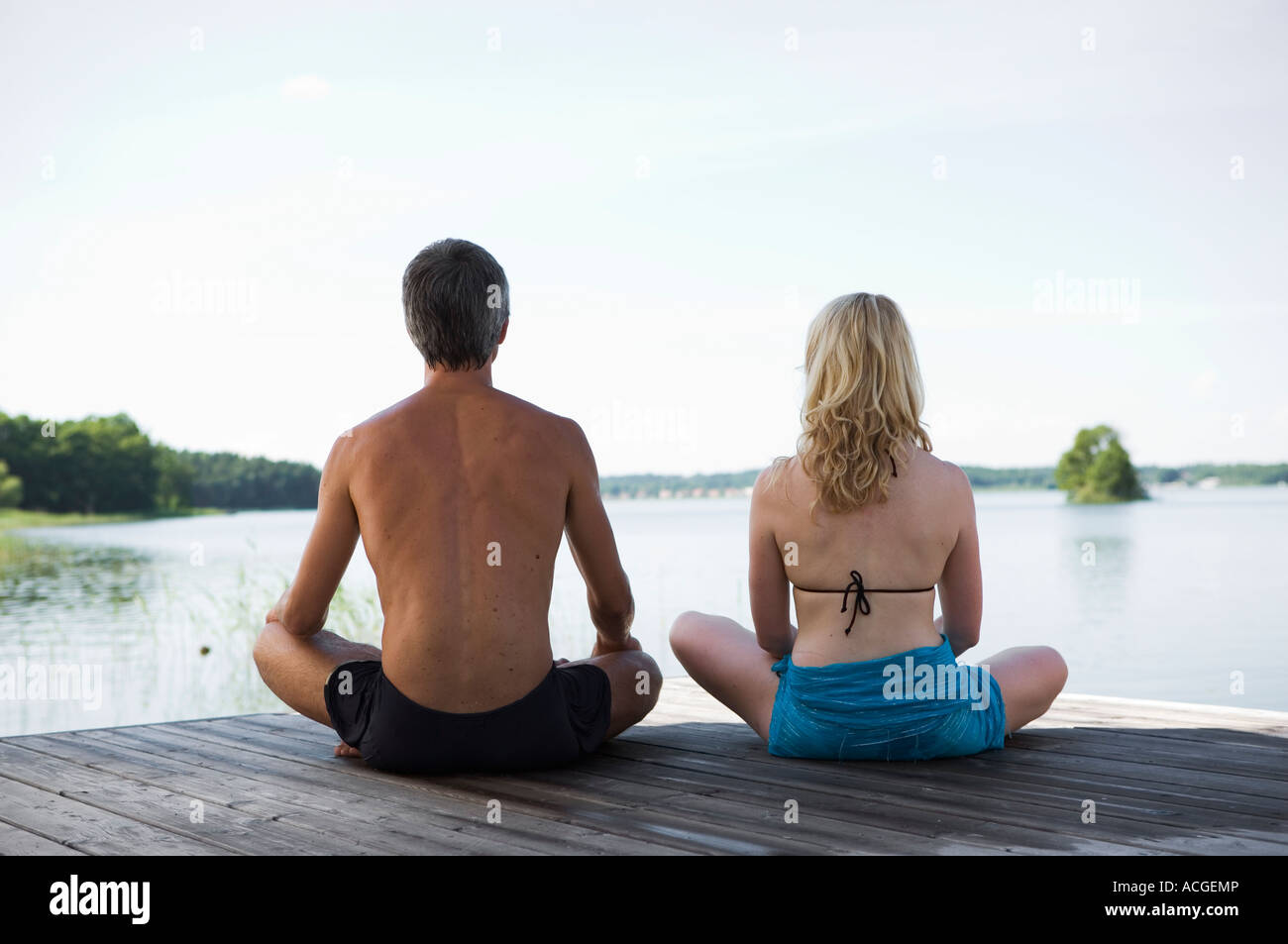 Un hombre y una mujer sentada sobre un puente con las piernas cruzadas  vista trasera Fotografía de stock - Alamy