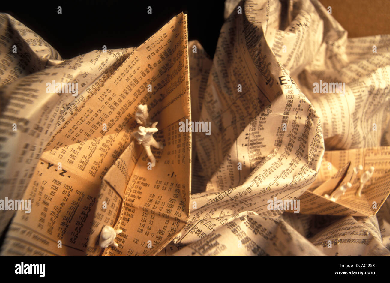 Pequeñas figuras en un barco de papel hecho a partir de una página de un  periódico con las cotizaciones del mercado bursátil Fotografía de stock -  Alamy