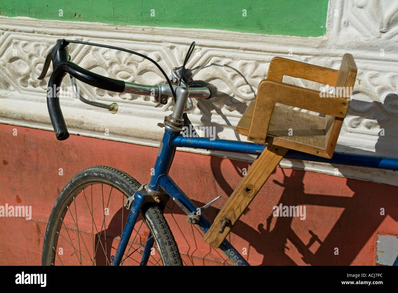 Bicicleta con un asiento de bebé de madera estacionada contra una pared,  Trinidad, Sancti Spíritus, Cuba Fotografía de stock - Alamy