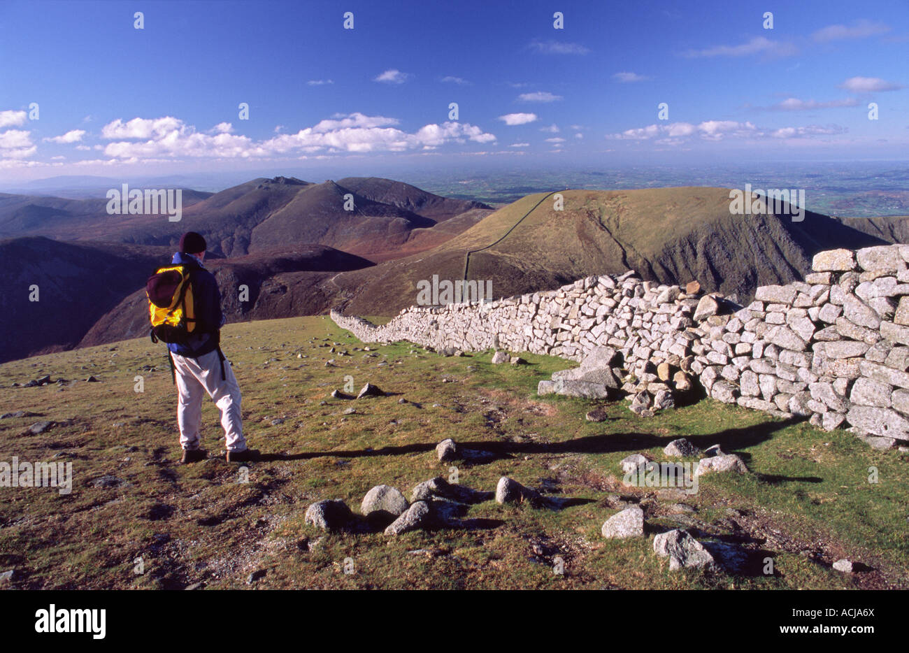 Walker, mirando a las Montañas Mourne, desde la cumbre de Slieve Donard. El condado de Down, Irlanda del Norte. Foto de stock