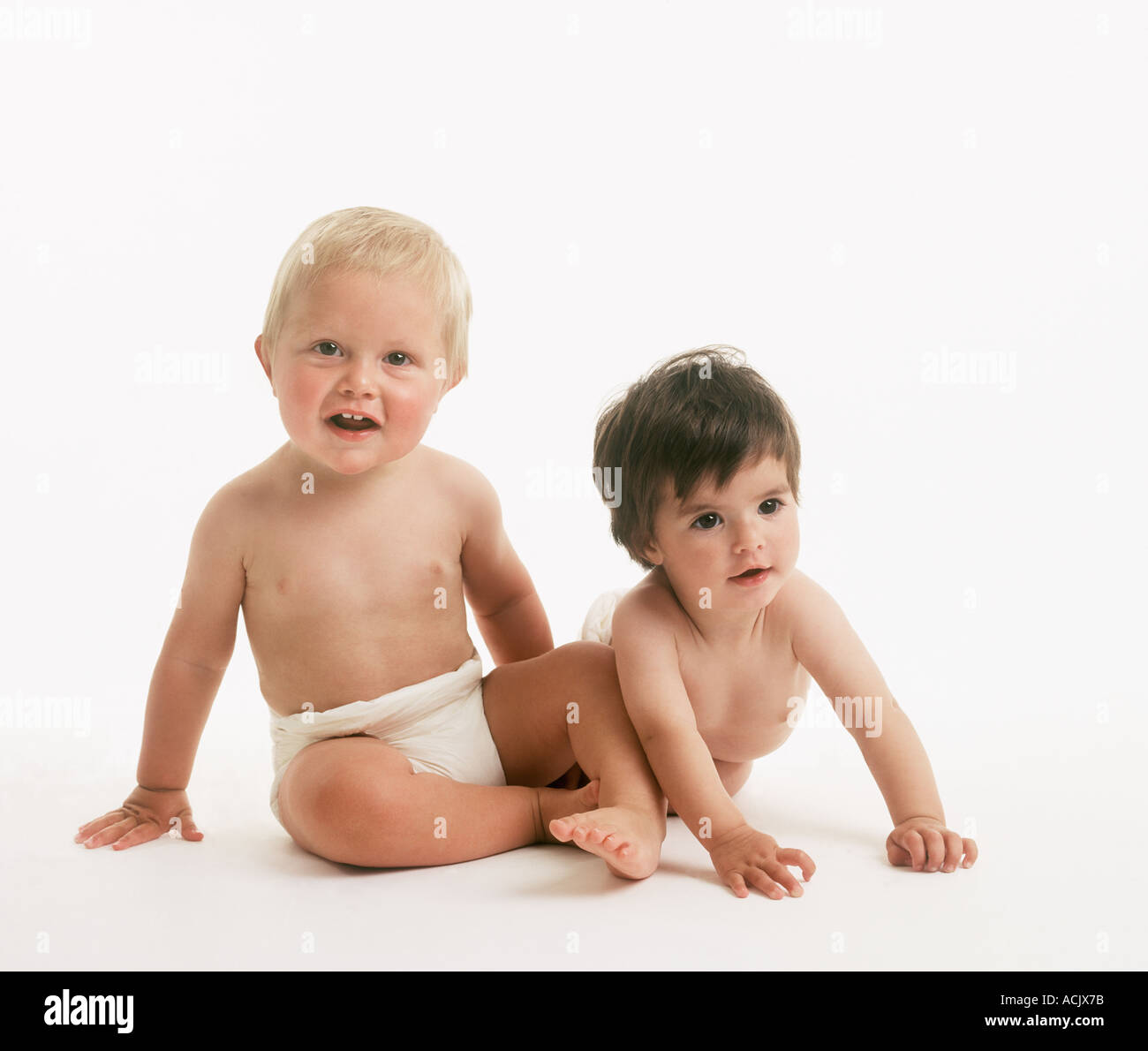 Niño y niña bebés en pañales pañales entre aproximadamente 10 y 6 meses,  sentarse y acostarse sobre fondo blanco Fotografía de stock - Alamy