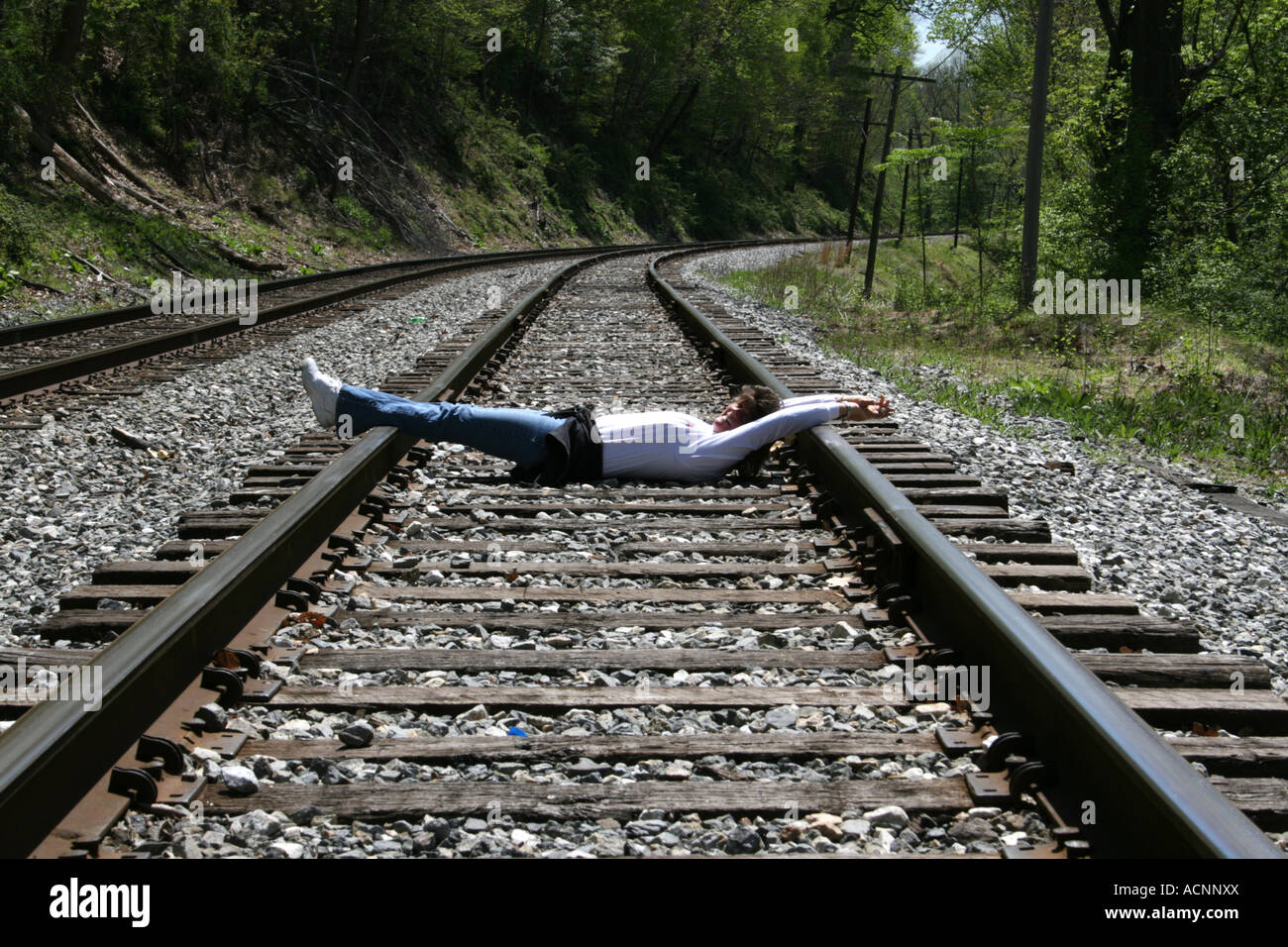 Mujer acostada sobre las vías de ferrocarril con las manos y los pies  amarrados Fotografía de stock - Alamy