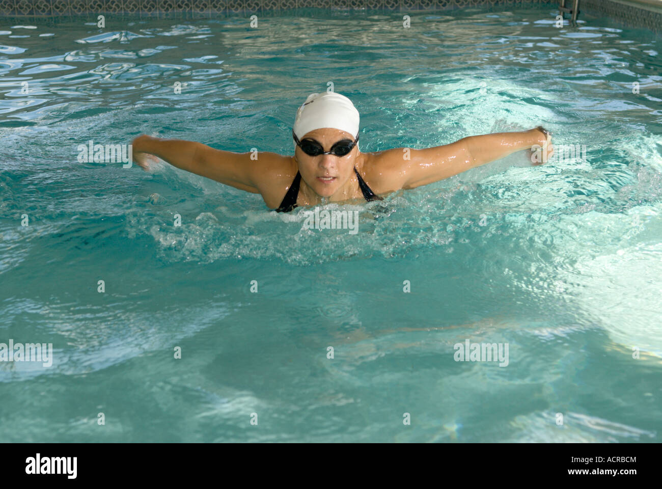 Mujer Mariposa de natación en la piscina cubierta de trazo Foto de stock
