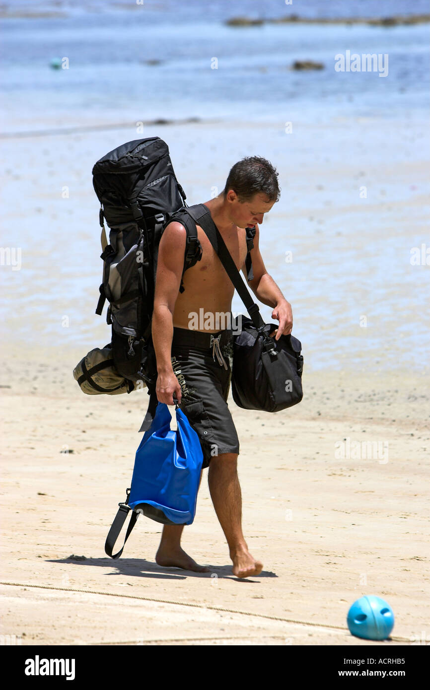 Backpacker paseos a lo largo de Hat Sai Ri playa azul con bolsa impermeable Ko Tao Island Tailandia Foto de stock