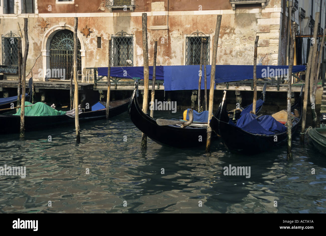 Las góndolas de Venecia Italia asientos vacíos flotando sobre el estrecho canal Foto de stock