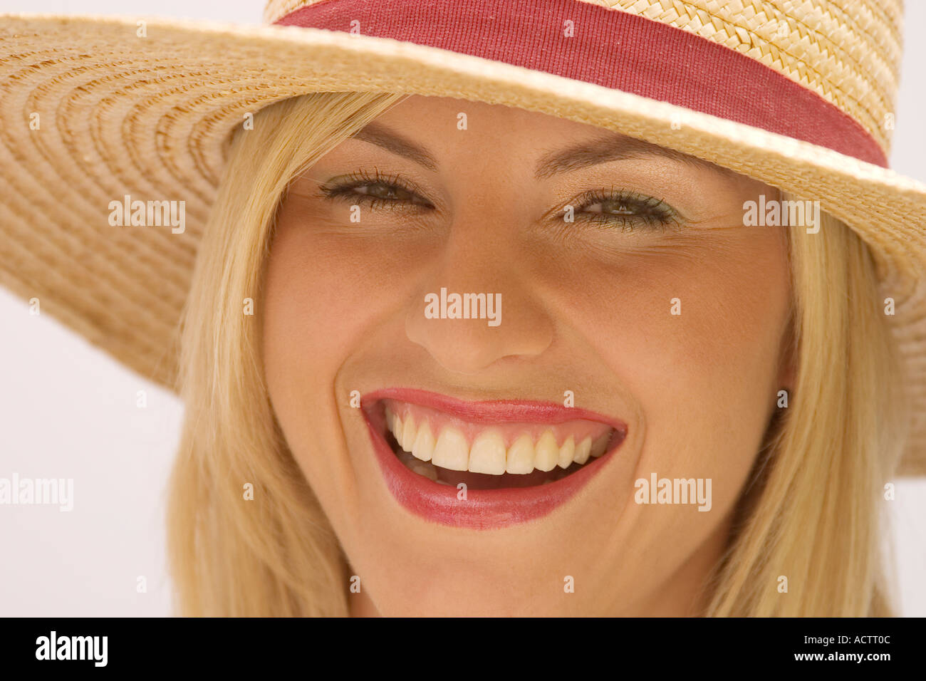 Laughing mujer rubia con sombrero de paja Foto de stock