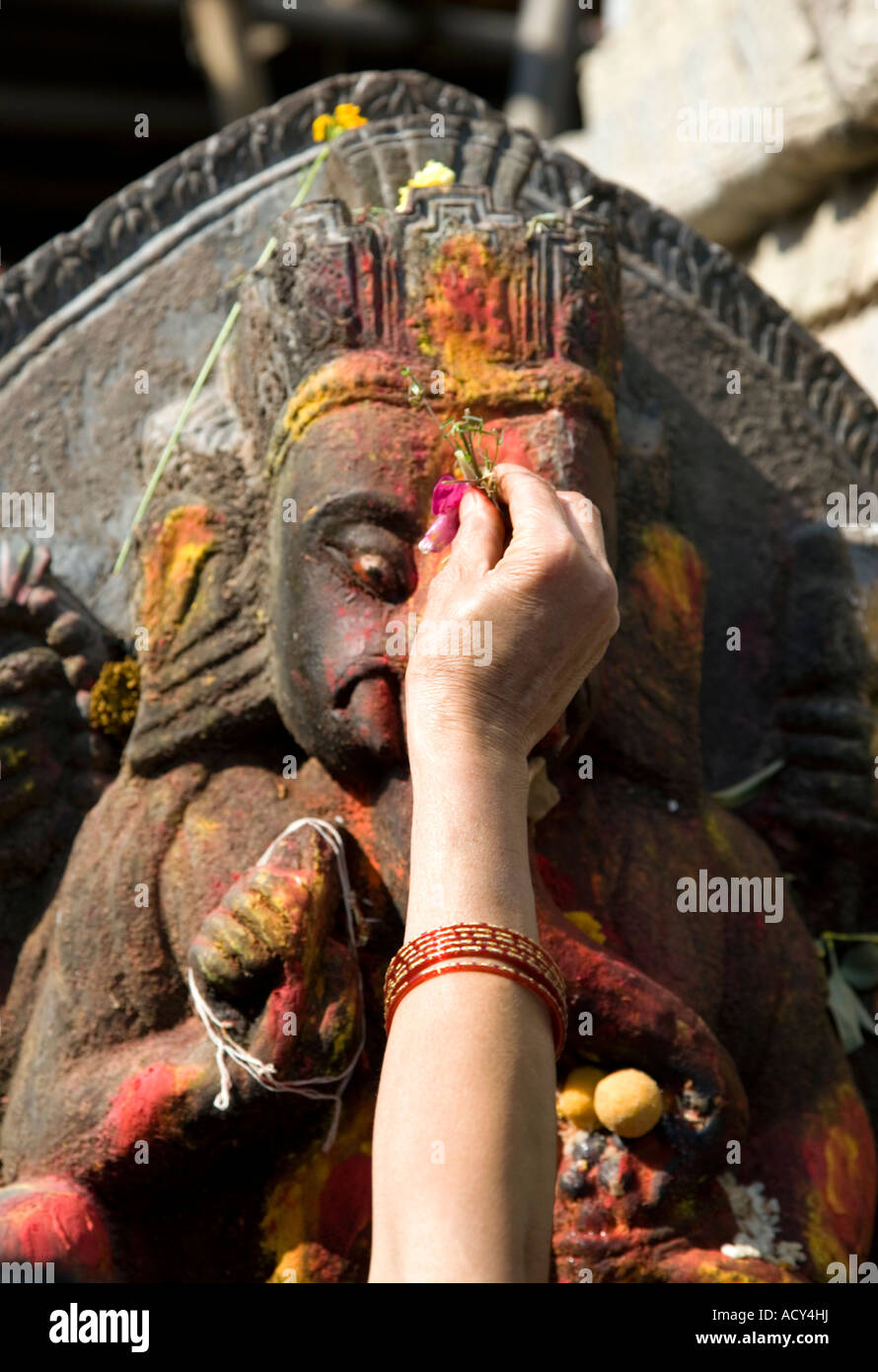 Mujer haciendo una ofrenda de flores a Ganesha.La Plaza Durbar de Katmandú.en Nepal. Foto de stock