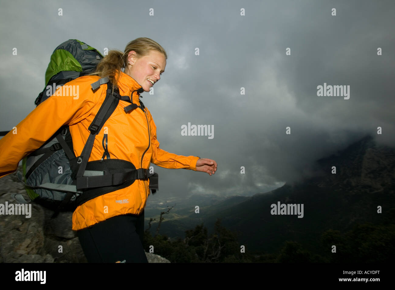 Mochilero femenino en las altas montañas con proximidad de tormentas Foto de stock