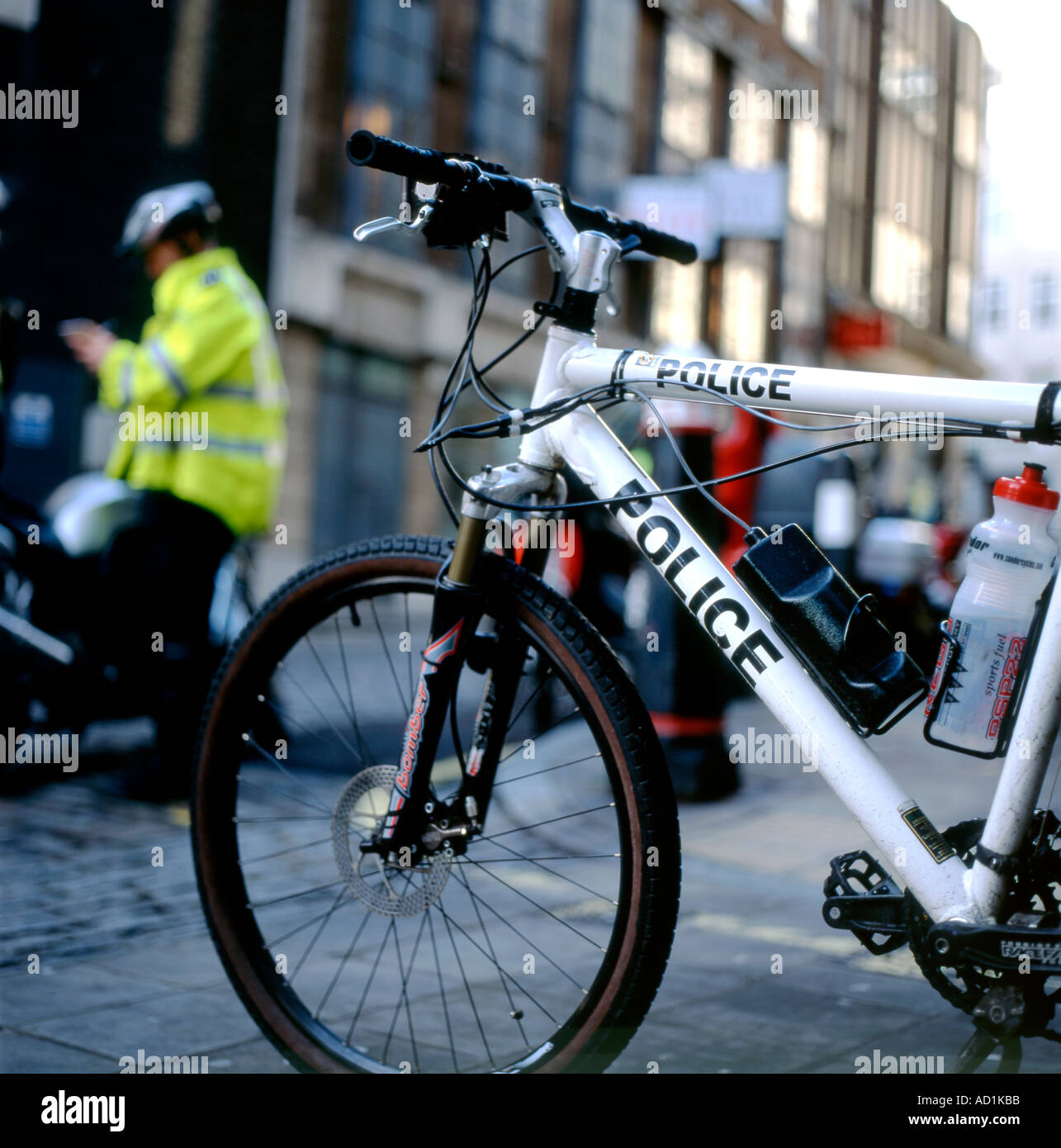 La policía en bicicleta London Street con un policía escribir un billete para un mal aparcado motocicleta UK KATHY DEWITT Foto de stock