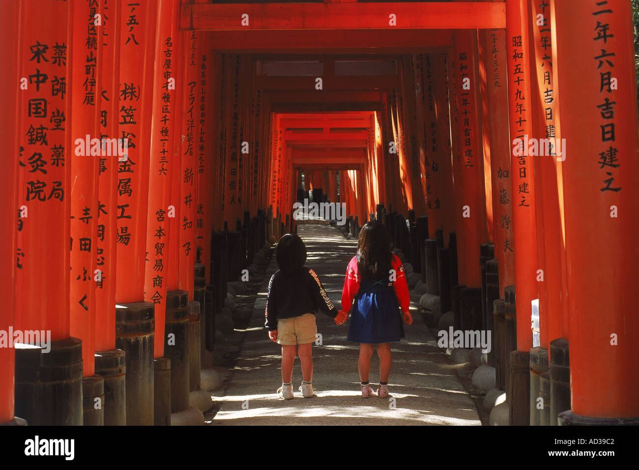 Los niños menores de Torii Gates en Fushimi Inari Shrine en Kioto, Japón Foto de stock