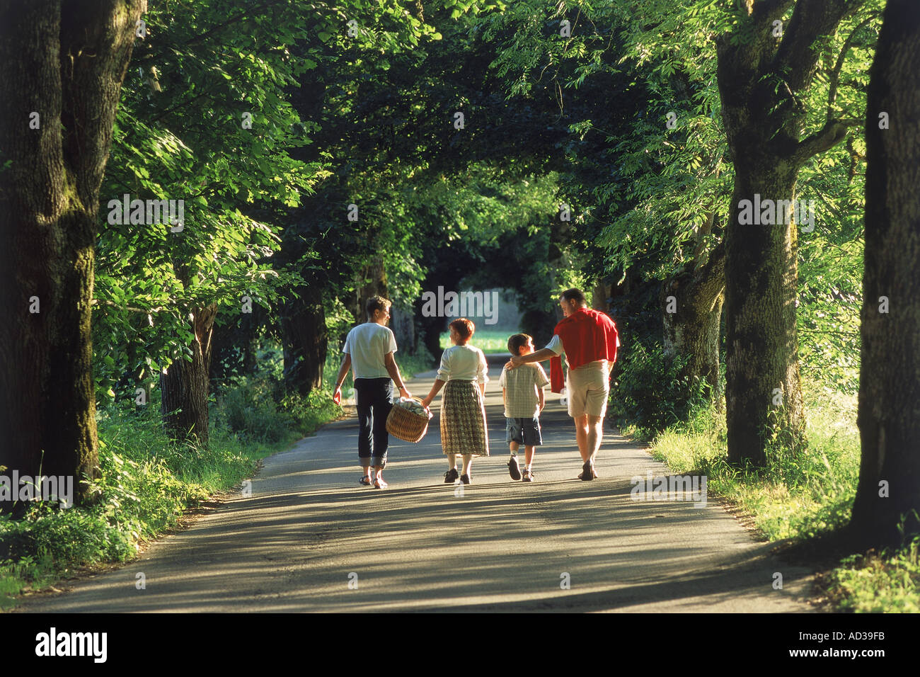 Una familia de cuatro, pasear por la carretera rural cerca de Munich, Alemania Foto de stock