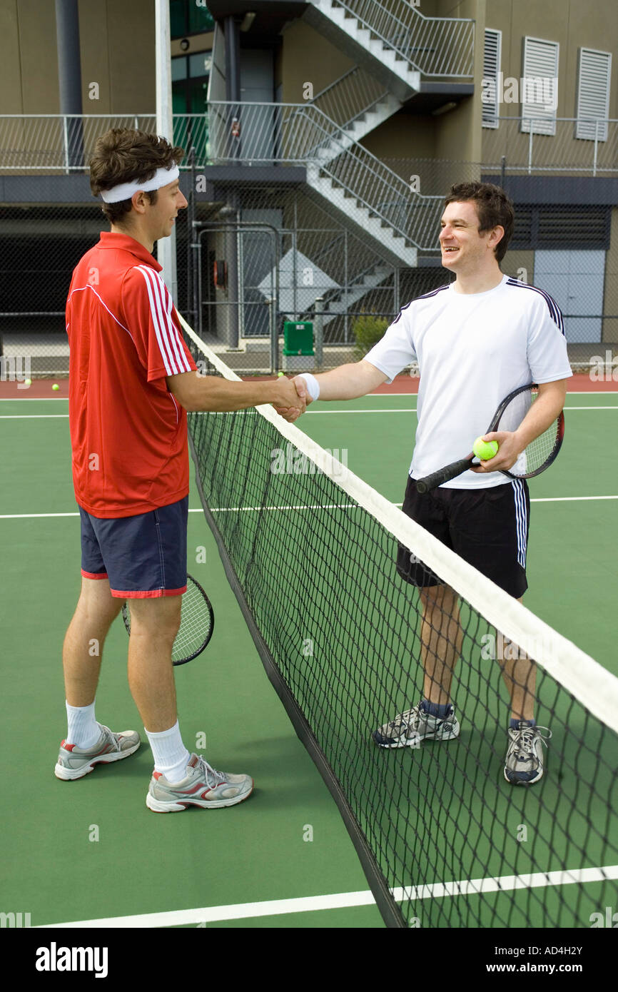 Dos jugadores de tenis un apretón de manos a través de la red Foto de stock
