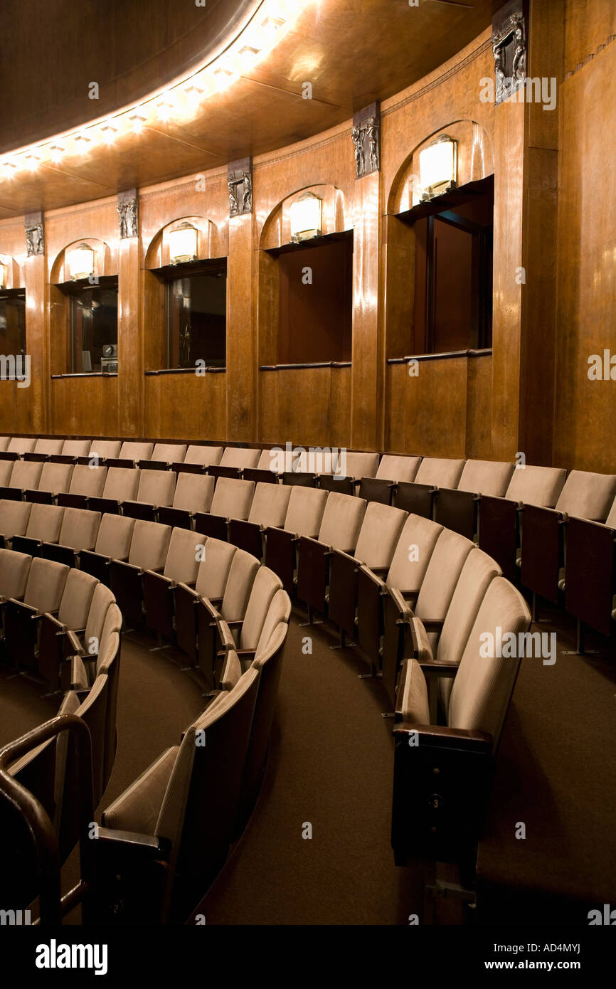 Filas de asientos vacíos en un teatro art deco iluminada Foto de stock